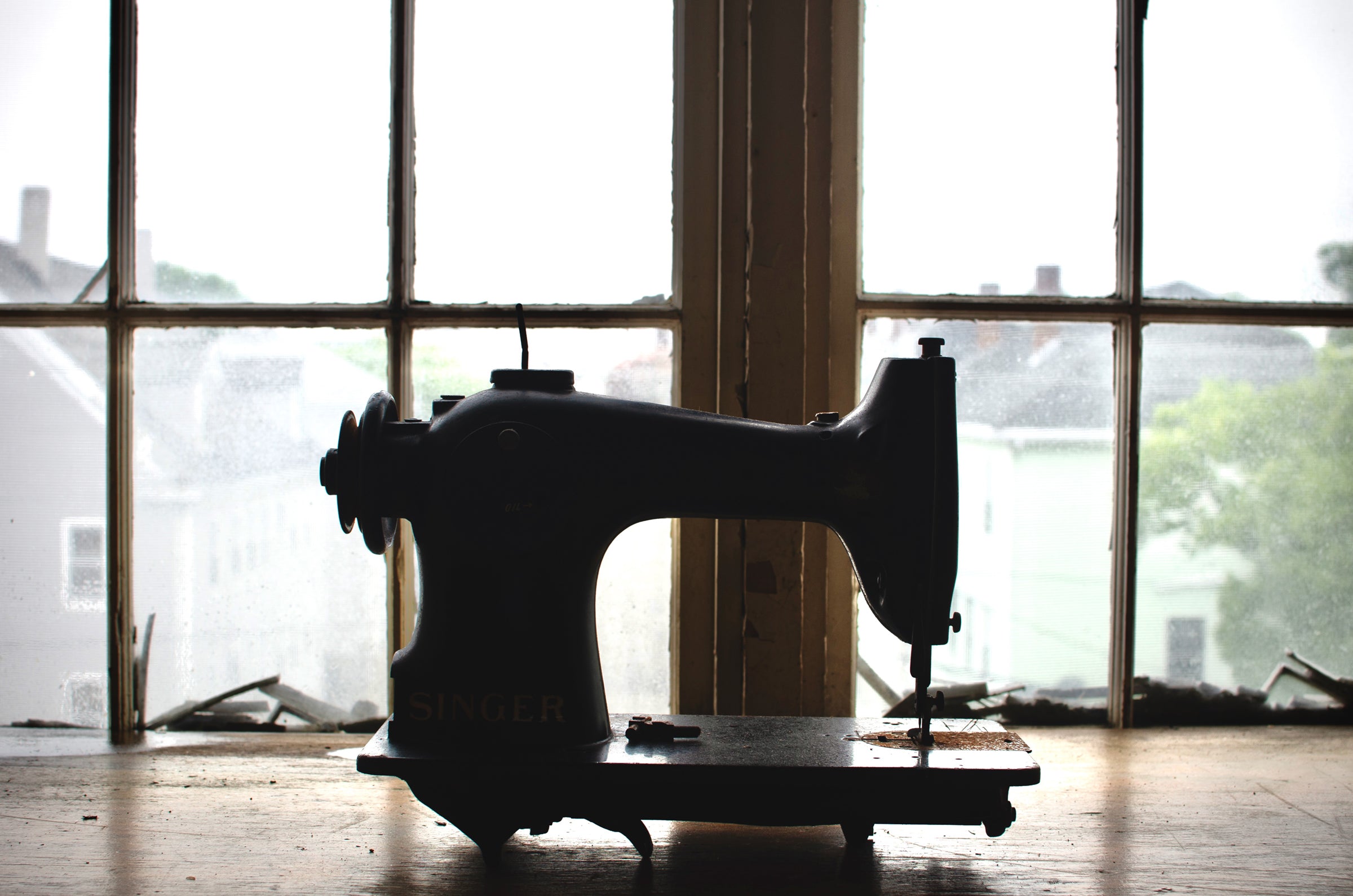 Vintage sewing machine sitting in textile mill window